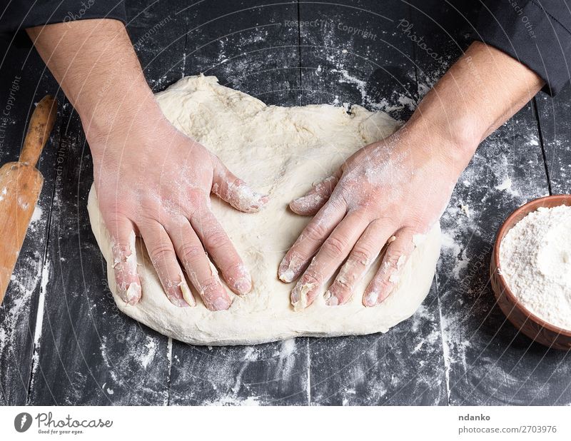 men's hands knead a round piece of dough for making pizza Dough Baked goods Bread Nutrition Bowl Table Kitchen Work and employment Cook Human being Man Adults