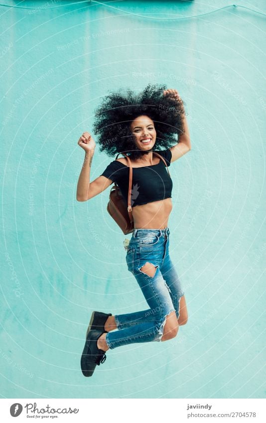 Young mixed woman with afro hair jumping outdoors. Lifestyle Style Happy Hair and hairstyles Face Human being Feminine Young woman Youth (Young adults) Woman