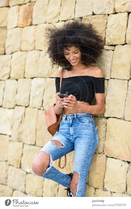 Smiling woman looking at her smart phone outdoors Lifestyle Style Joy Happy Beautiful Hair and hairstyles Telephone PDA Technology Human being Feminine