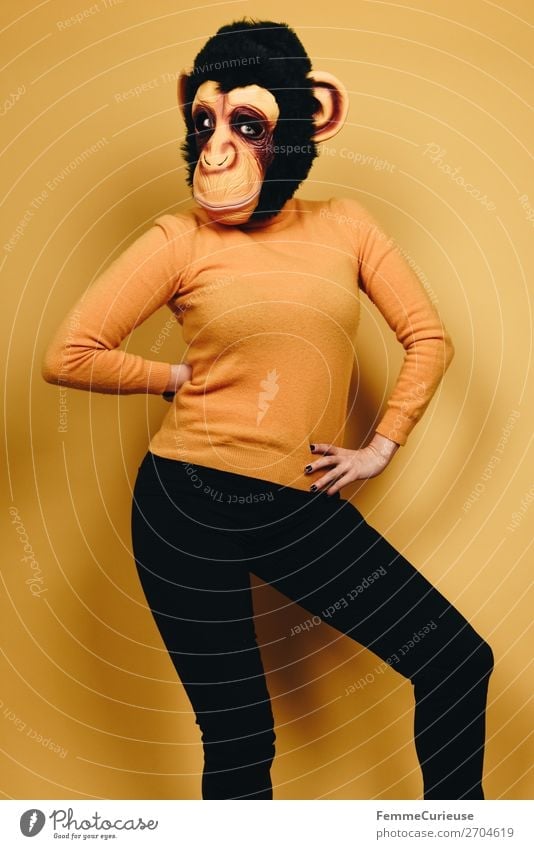 Woman with monkey mask posing against a yellow background Feminine Adults 1 Human being 18 - 30 years Youth (Young adults) 30 - 45 years Joy Monkeys Chimpanzee
