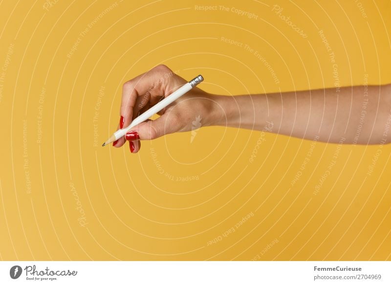 Forearm and hand with pencil against a yellow background Feminine 1 Human being Communicate Hand Fingers Nail polish Red Yellow Draw Write Pencil Underarm