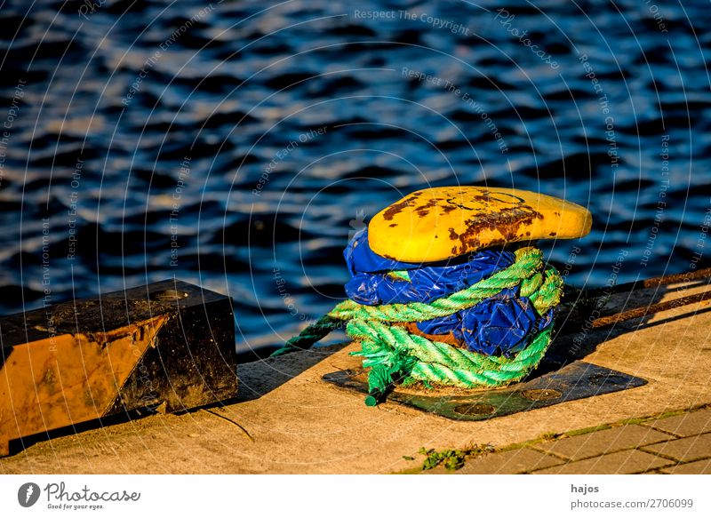 Harbour bollard with mooring rope Design Maritime Blue Yellow Bollard harbour bollards mooring lines Green Water Baltic Sea pier Navigation lash anchored fixed