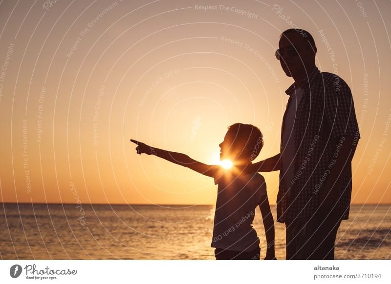 Father and son playing on the beach at the sunset time. People having fun outdoors. Concept of happy vacation and friendly family. Lifestyle Joy Happy