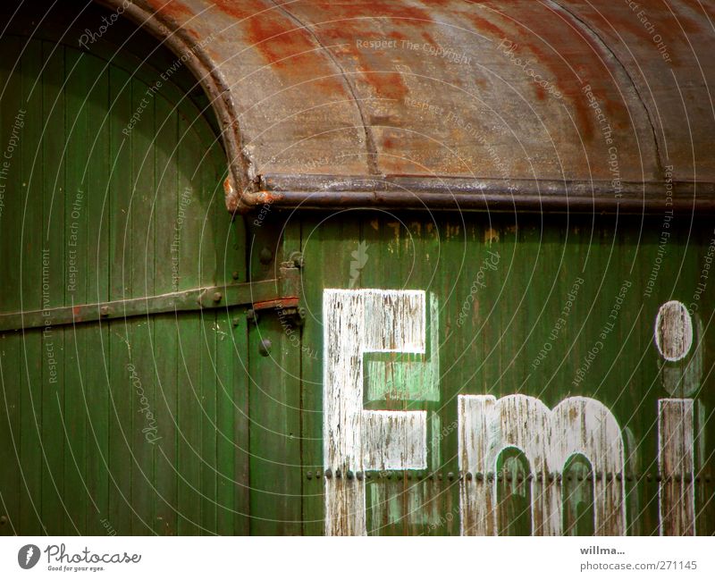 emi Letters (alphabet) Characters Text Old Historic Site trailer Trailer Railroad car Decline Past Transience Change Wooden wall Green White Logistics