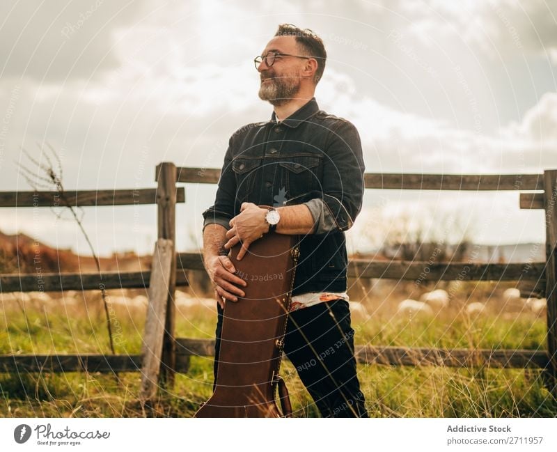 Adult man with guitar case Man Guitar Nature Musician To fall Stand Looking away Adults Rural Fence Lifestyle Human being Summer Easygoing Acoustic handsome Guy