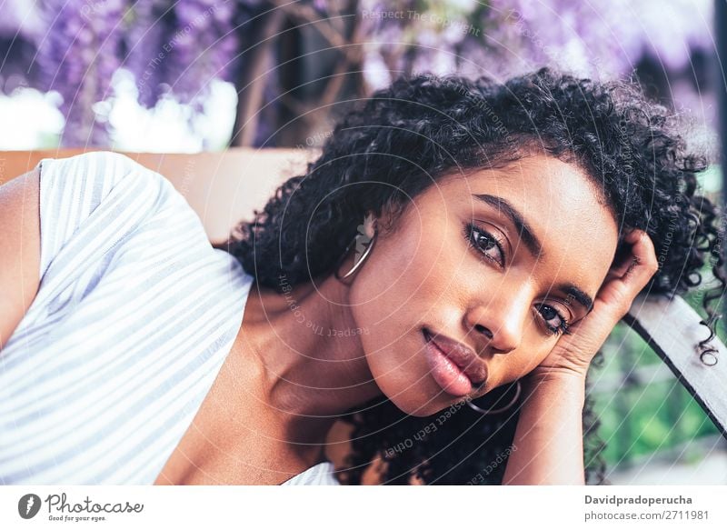 Young black woman laying down on a chair surrounded by flowers Woman Blossom Spring Lilac Portrait photograph multiethnic Black African Mixed race ethnicity
