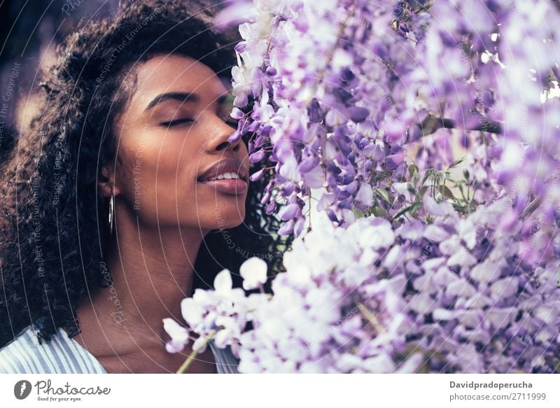 Thoughtful happy young black woman surrounded by flowers Woman Blossom Spring Lilac Close-up multiethnic Black African Mixed race ethnicity To enjoy Happy