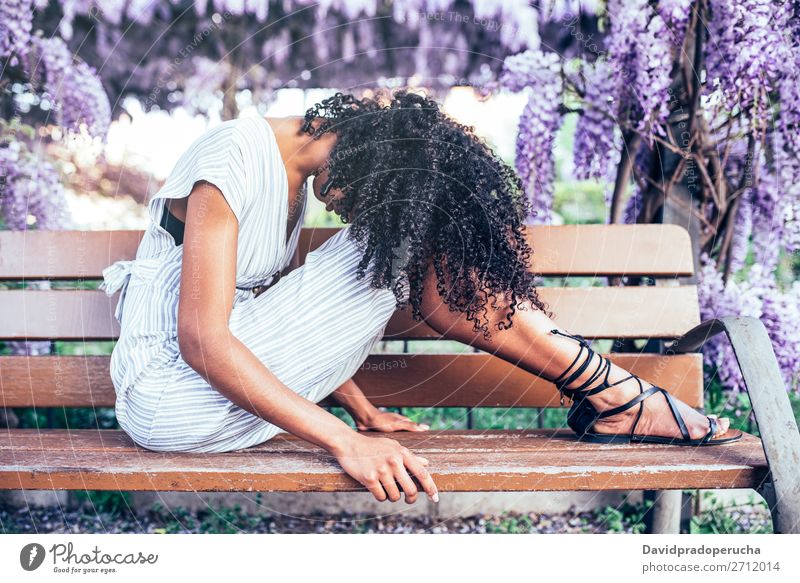 Young sad black woman sitting surrounded by flowers Woman Blossom Considerate Spring Lilac Portrait photograph multiethnic Black African Mixed race ethnicity