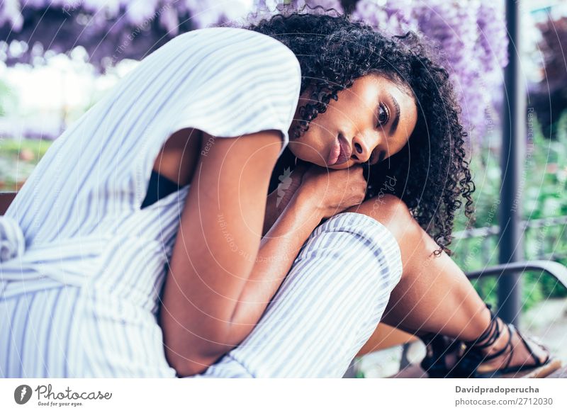 Young sad black woman sitting surrounded by flowers Woman Blossom Considerate Spring Lilac Portrait photograph multiethnic Black African Mixed race ethnicity