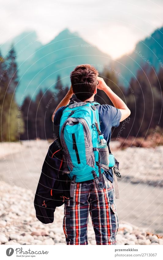 Young wanderer with backpack looks through a binoculars Lifestyle Leisure and hobbies Vacation & Travel Tourism Trip Adventure Summer Mountain Human being