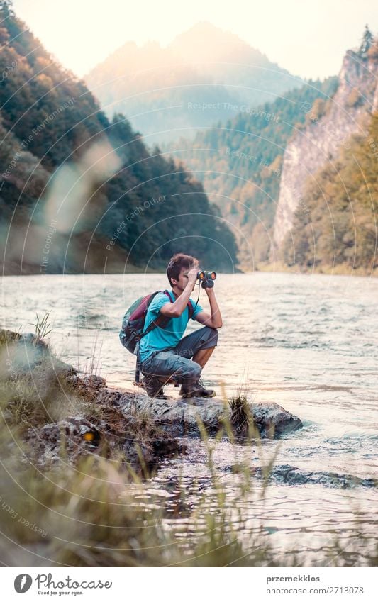 Young tourist with backpack looks through a binoculars Lifestyle Leisure and hobbies Vacation & Travel Trip Summer Mountain Human being Boy (child) Young man