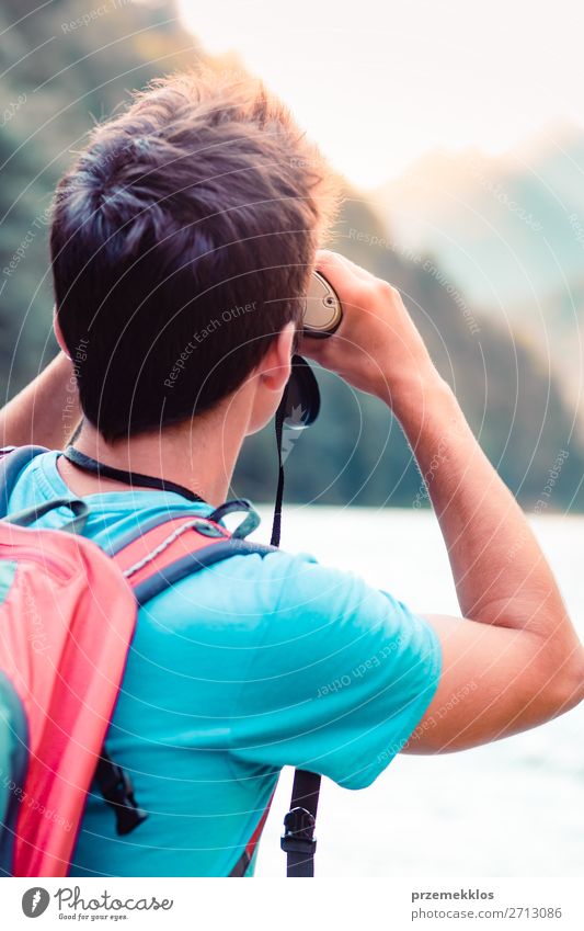 Young tourist with backpack looks through a binoculars Lifestyle Leisure and hobbies Vacation & Travel Trip Summer Mountain Human being Boy (child) Young man