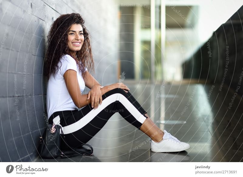 African woman with black curly hairstyle sitting on urban floor. Lifestyle Style Happy Beautiful Hair and hairstyles Face Sports Human being Feminine