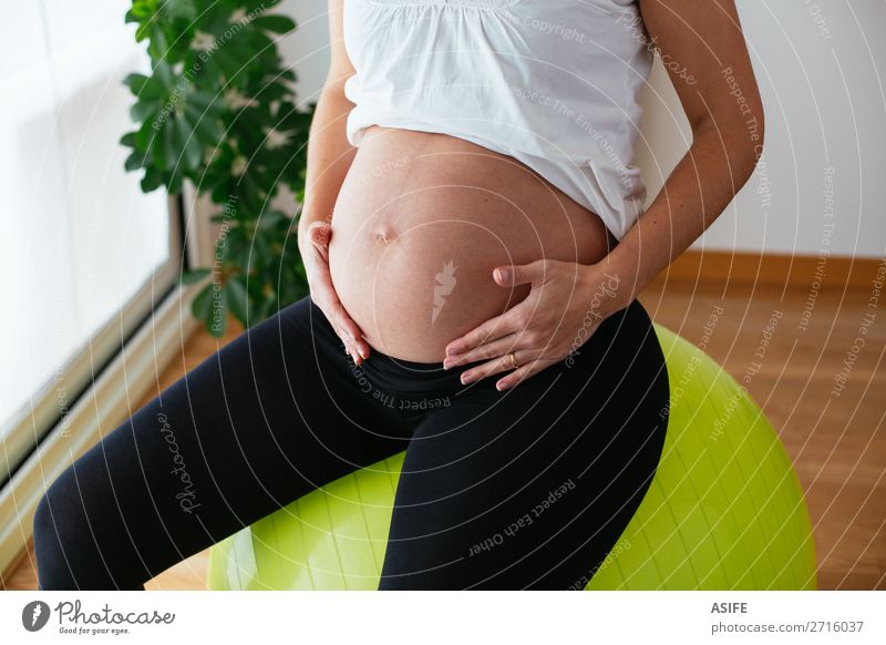 Pregnant woman exercising at home sitting on the fitball Happy Body Sports Baby Woman Adults Parents Mother Hand Touch Fitness Sit Green Future pregnancy