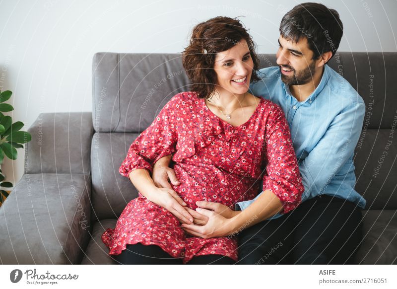 Hapy pregnant couple on the sofa Happy Beautiful Body Baby Woman Adults Man Parents Mother Father Family & Relations Couple Flower Dress Touch Smiling Love Sit