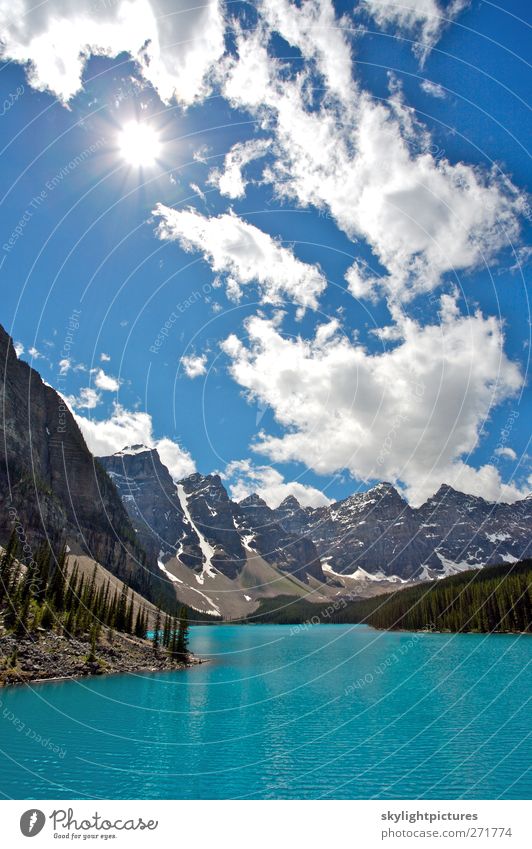 Summer day at beautiful Moraine Lake Tourism Sightseeing Sun Waves Mountain Hiking Nature Landscape Sky Clouds Beautiful weather Tree Forest Peak