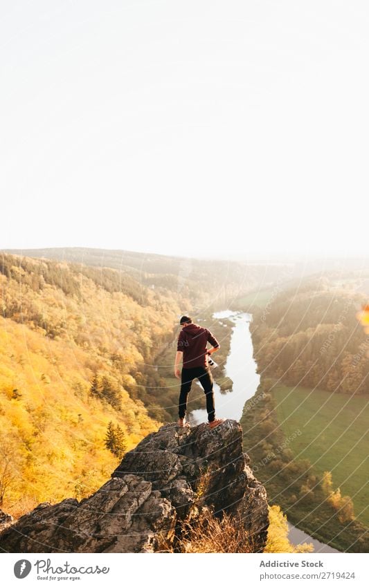 Man on edge of cliff on nature traveler Valley Autumn exploration Height Cliff Mountain terrain Vantage point Vacation & Travel Nature Dream Trip Calm River