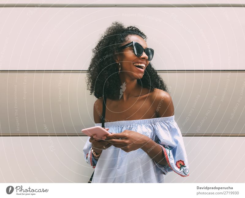 Cheerful black woman with mobile phone Woman Wall (building) Adults Easygoing PDA African Ethnic Cellphone Copy Space Youth (Young adults) Lifestyle pastel