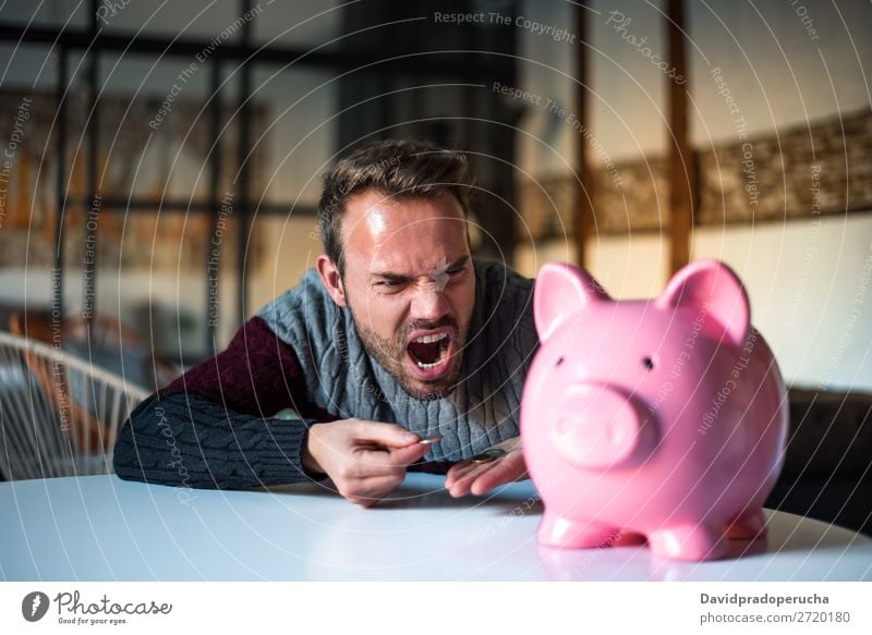 Unhappy man angry at his piggy bank Man Money box savings Crisis Sadness Anger Stress Emotions annoyed Scream trouble Expression frustrated Problem shouting