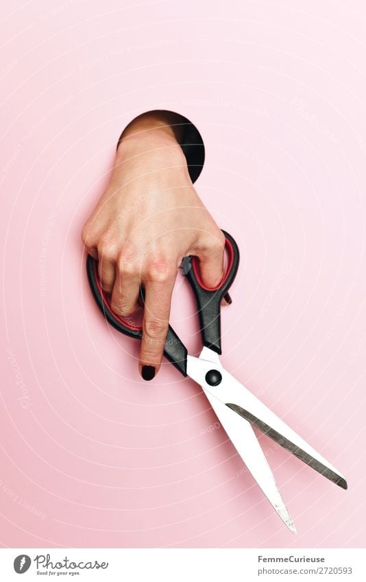 Close Up Of Hand Holding Scissors And Cutting Through Paper Stock