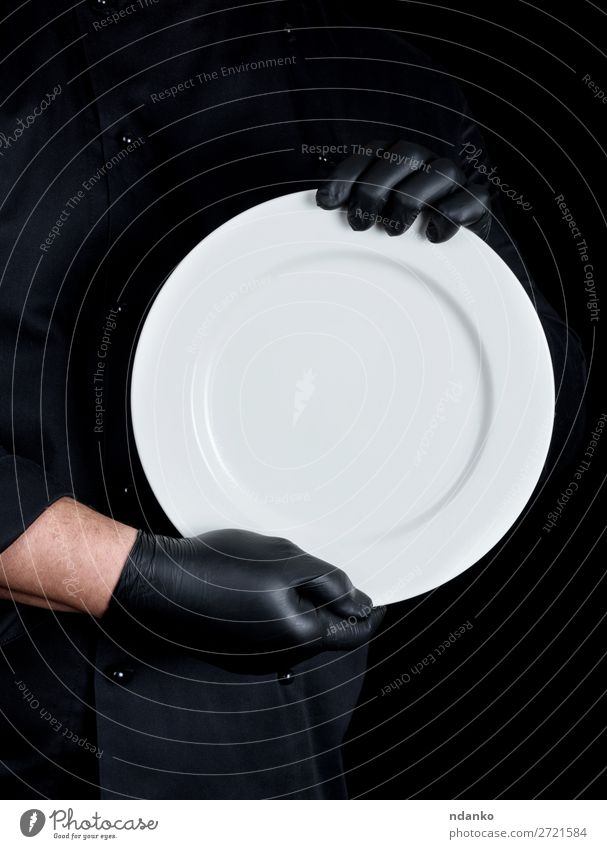 Chef in black uniform holding a round empty plate Plate Kitchen Restaurant Profession Cook Human being Man Adults Hand Gloves Dark Black White Caucasian chef