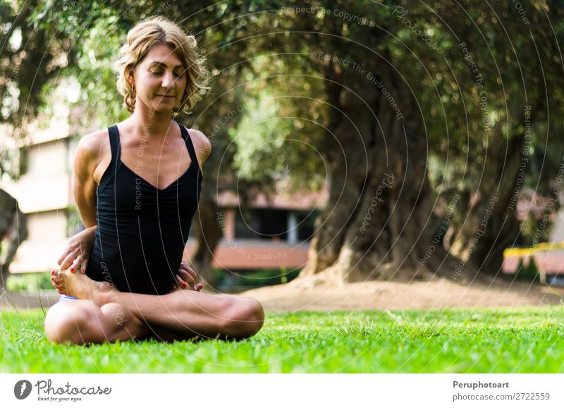 Woman practicing yoga .The Locked Lotus Pose Baddha Padmasana. Diet Lifestyle Beautiful Body Relaxation Meditation Leisure and hobbies Sports Yoga Adults Park