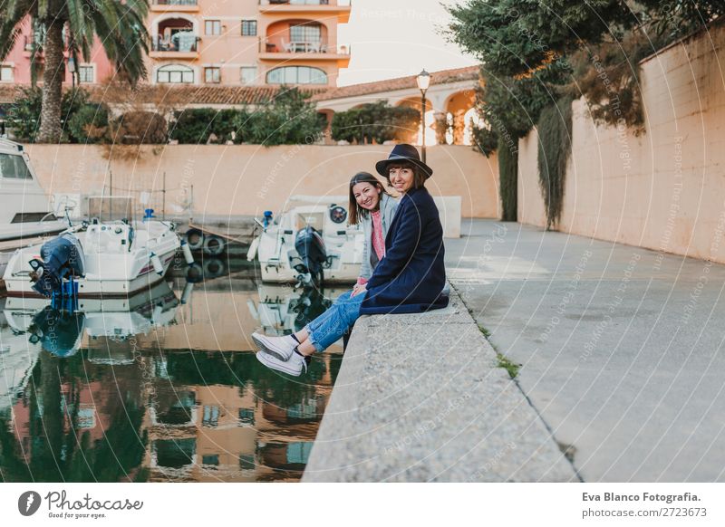 Two happy friends sitting on the dock at the port Lifestyle Joy Happy Sun House (Residential Structure) Meeting To talk Woman Adults Family & Relations