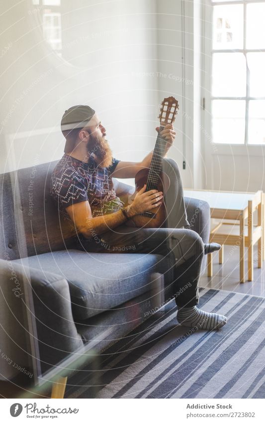 Man playing guitar in armchair Home Relaxation Adults bearded Sit Armchair Playing Guitar Musician Acoustic Easygoing Youth (Young adults)