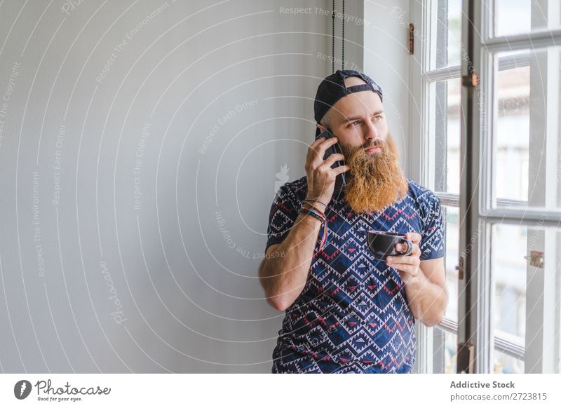 Man with cup and phone at window Home Relaxation Adults bearded PDA To talk To call someone (telephone) Cup Mug Hot Drinking Communication Window Easygoing