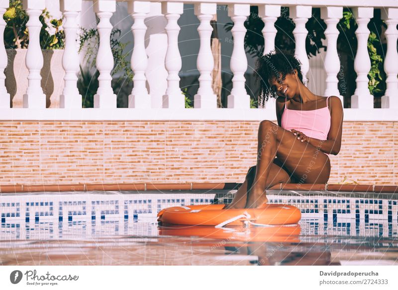 Black woman in a swimming pool with lifesaver Woman Ethnic Swimming pool Summer Lifeguard Sunbathing Barefoot Legs Pedicure Relaxation Skin tan Water