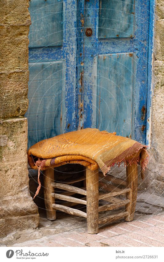Small stool with blanket, standing in front of blue door, in the medina. Vacation & Travel Tourism Trip Sightseeing City trip Chair