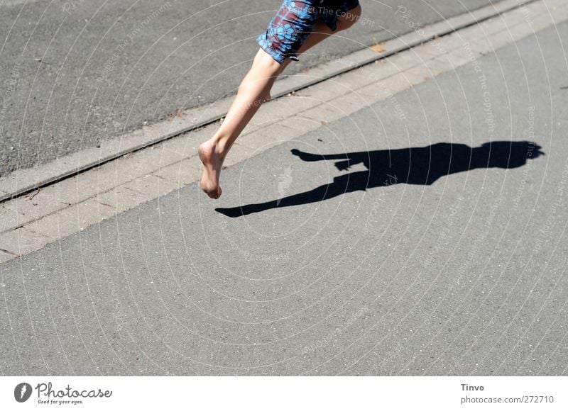 Legs of boy bouncing over asphalt and body shadows Feet 1 Human being Sunlight Summer Beautiful weather Traffic infrastructure Pedestrian Street Walking Running