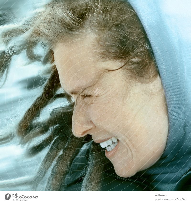 Laughing woman with dreadlocks and hood in stormy wind Young woman Youth (Young adults) Face Wind Gale Hooded (clothing) Dreadlocks Laughter Authentic Happy Joy