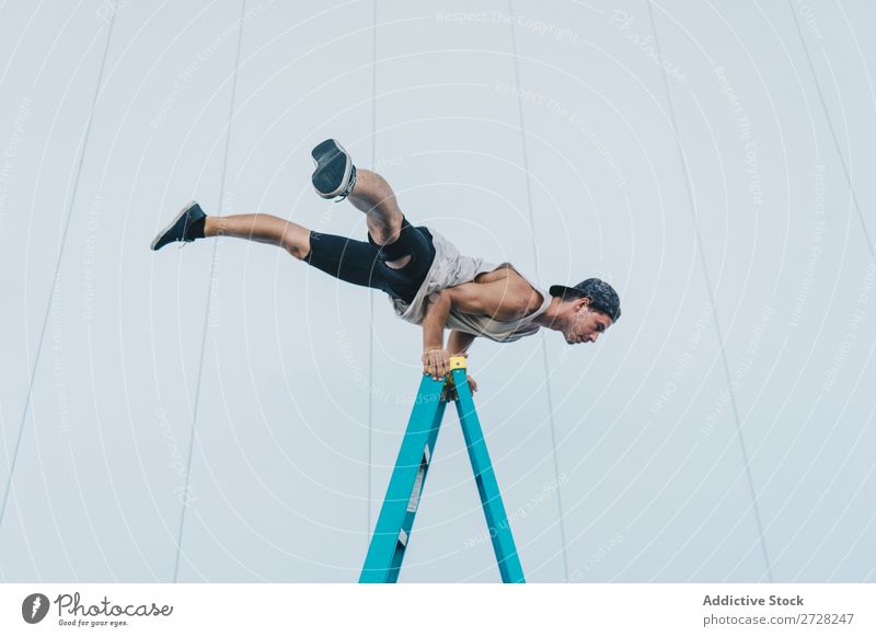 Man balancing on ladder - a Royalty Free Stock Photo from Photocase
