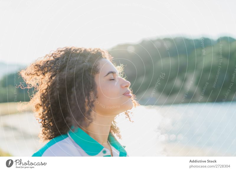 Curly woman posing on nature in sunlight Woman Summer To enjoy Posture human face Landscape Nature Colour Portrait photograph tranquil Exterior shot Countries