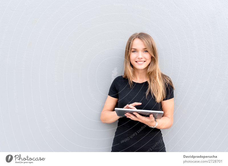 Happy young woman on the tablet by the wall Woman Isolated Blonde Tablet computer Technology Coffee Youth (Young adults) Black Dress Beauty Photography City