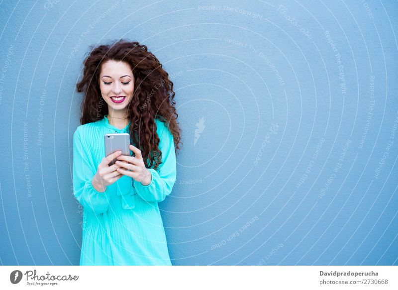 Happy young woman on the mobile phone by a colorful wall Woman Red-haired Telephone Business Businesswoman Technology Mobile Smiling Face Beauty Photography