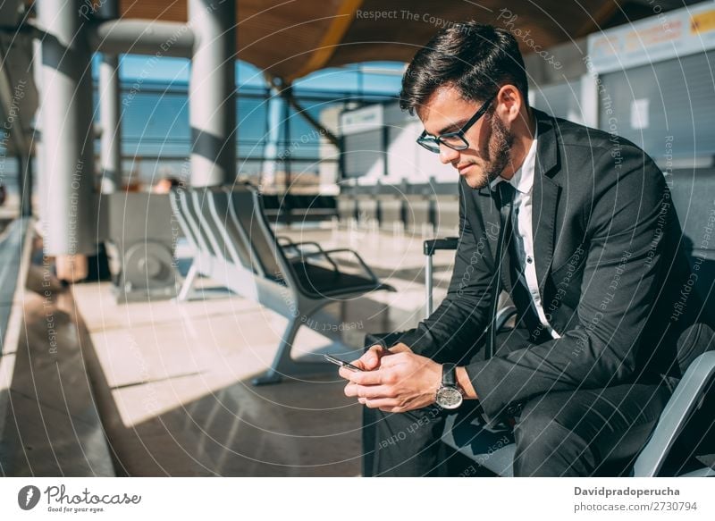 Young business man sitting on the phone with the suitcase at the airport waiting for the flight Airport Man Vacation & Travel Mobile Telephone Communication