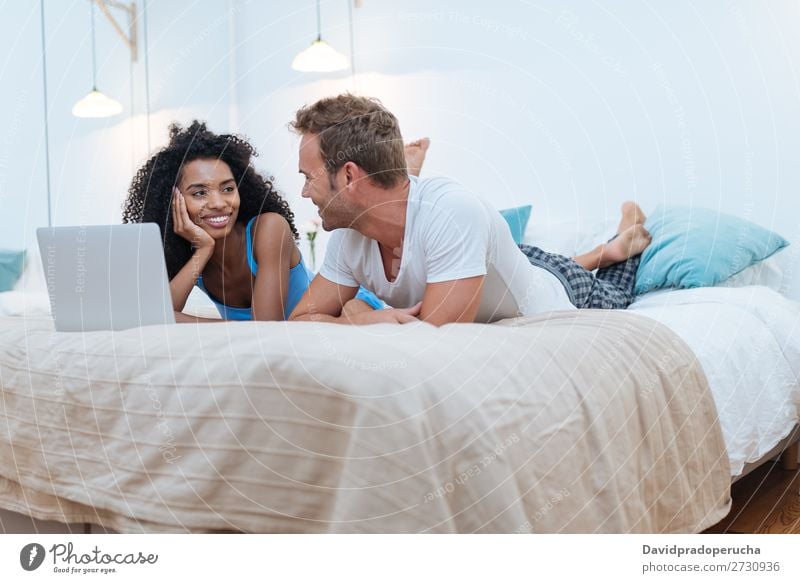 Happy Young Couple Relaxed At Home Lying Down In Bed On The