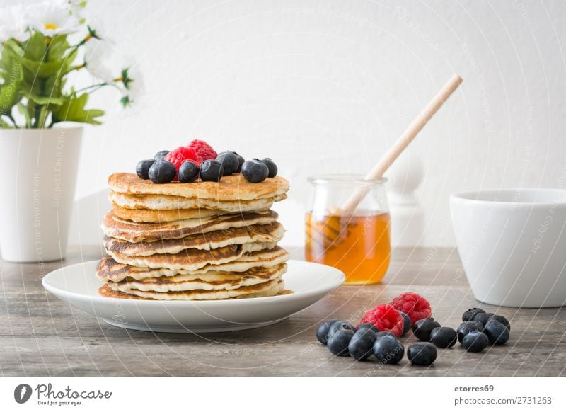 Pouring honey in pancakes with raspberries and blueberries Pancake Candy Dessert Breakfast Blueberry Raspberry Berries Red Baking Food Healthy Eating