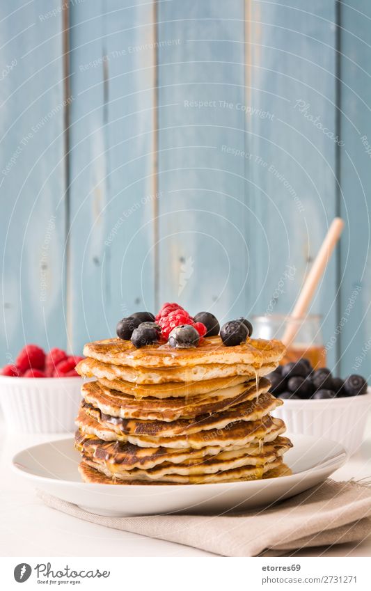 Pouring honey in pancakes with raspberries and blueberries Pancake Candy Dessert Breakfast Blueberry Raspberry Berries Red Baking Food Healthy Eating