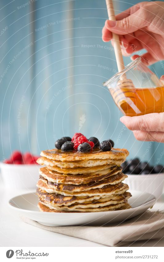 Pouring honey in pancakes with raspberries and blueberries Pancake Honey Candy Dessert Breakfast Blueberry Raspberry Berries Red Baking Food Healthy Eating