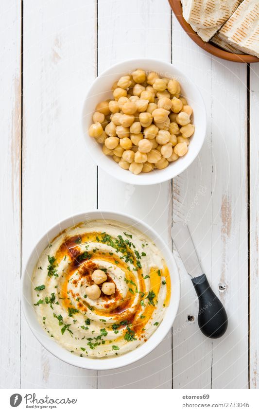 Hummus in bowl and pita bread on wooden table. Bread Food Healthy Eating Food photograph Dish Nutrition Chickpeas Coriander Lemon Olive oil Vegan diet Arabia