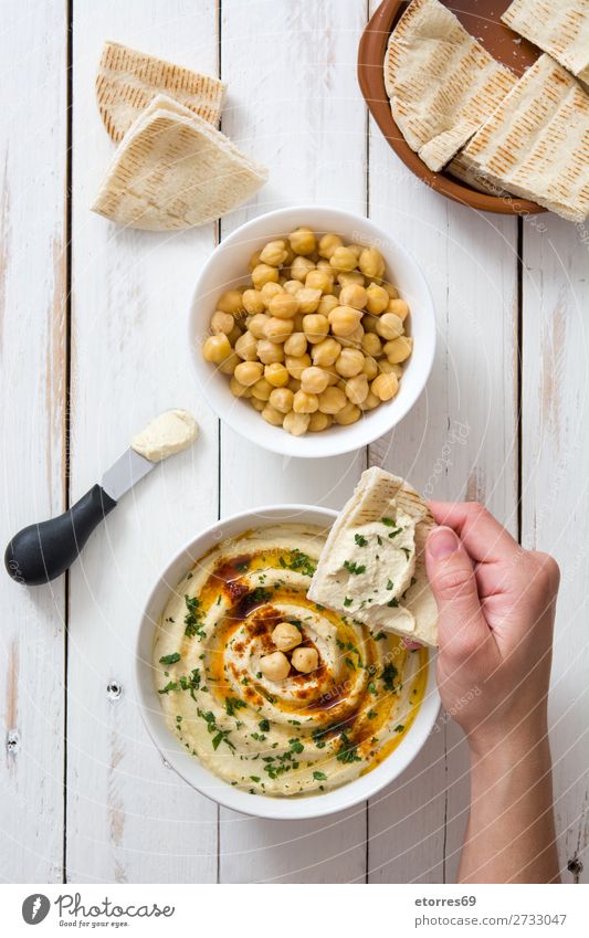 Hummus in bowl and pita bread on wooden table. Bread Food Healthy Eating Food photograph Dish Nutrition Chickpeas Coriander Lemon Olive oil Vegan diet Arabia