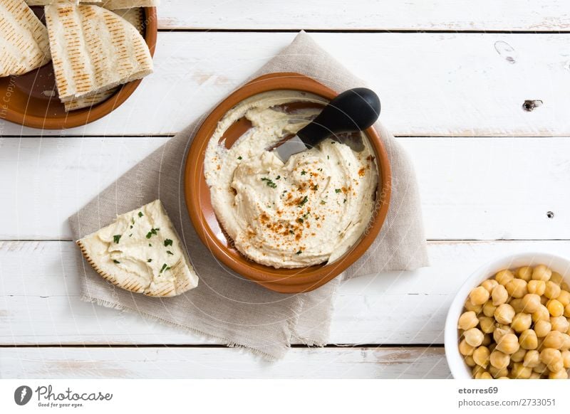 Hummus in bowl and pita bread on white wooden table. Bread Food Healthy Eating Food photograph Nutrition Chickpeas Coriander Lemon Olive oil Vegan diet Arabia