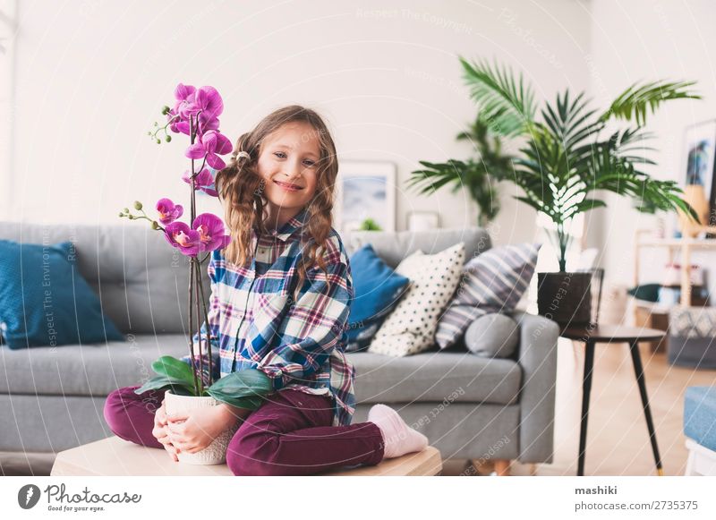 happy kid posing with orchid flower Pot Lifestyle Exotic Beautiful Flat (apartment) Living room Child Gardening Plant Flower Orchid Leaf Growth Small Modern New