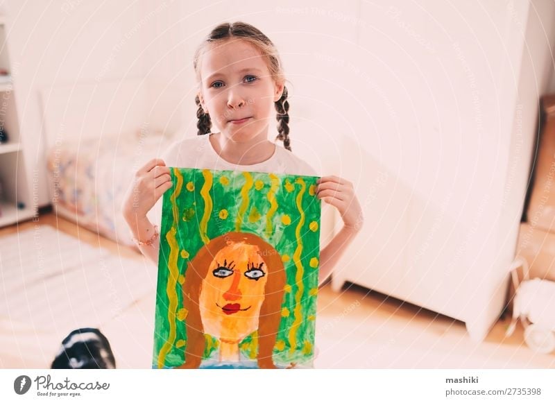 happy kid girl posing with drawing mom's portrait Lifestyle Happy Feasts & Celebrations Birthday Child Parents Adults Mother Family & Relations Infancy Art