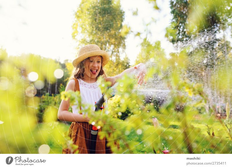 happy child girl watering flowers with hose in summer garden Lifestyle Leisure and hobbies Summer Garden Child Gardening Nature Landscape Plant Spring Flower