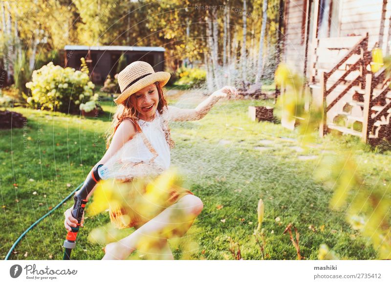 happy child girl watering flowers with hose in summer Lifestyle Joy Leisure and hobbies Playing Summer Garden Child Work and employment Gardening Nature