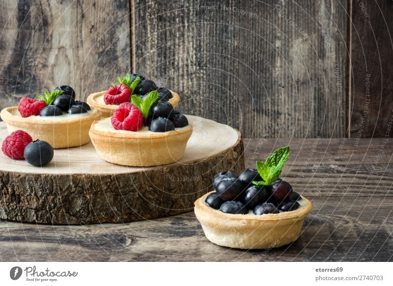 Delicious tartlets with raspberries and blueberries on trunk Tartlet Raspberry Blueberry Fruit Dessert Food Healthy Eating Food photograph Cream custard Snack
